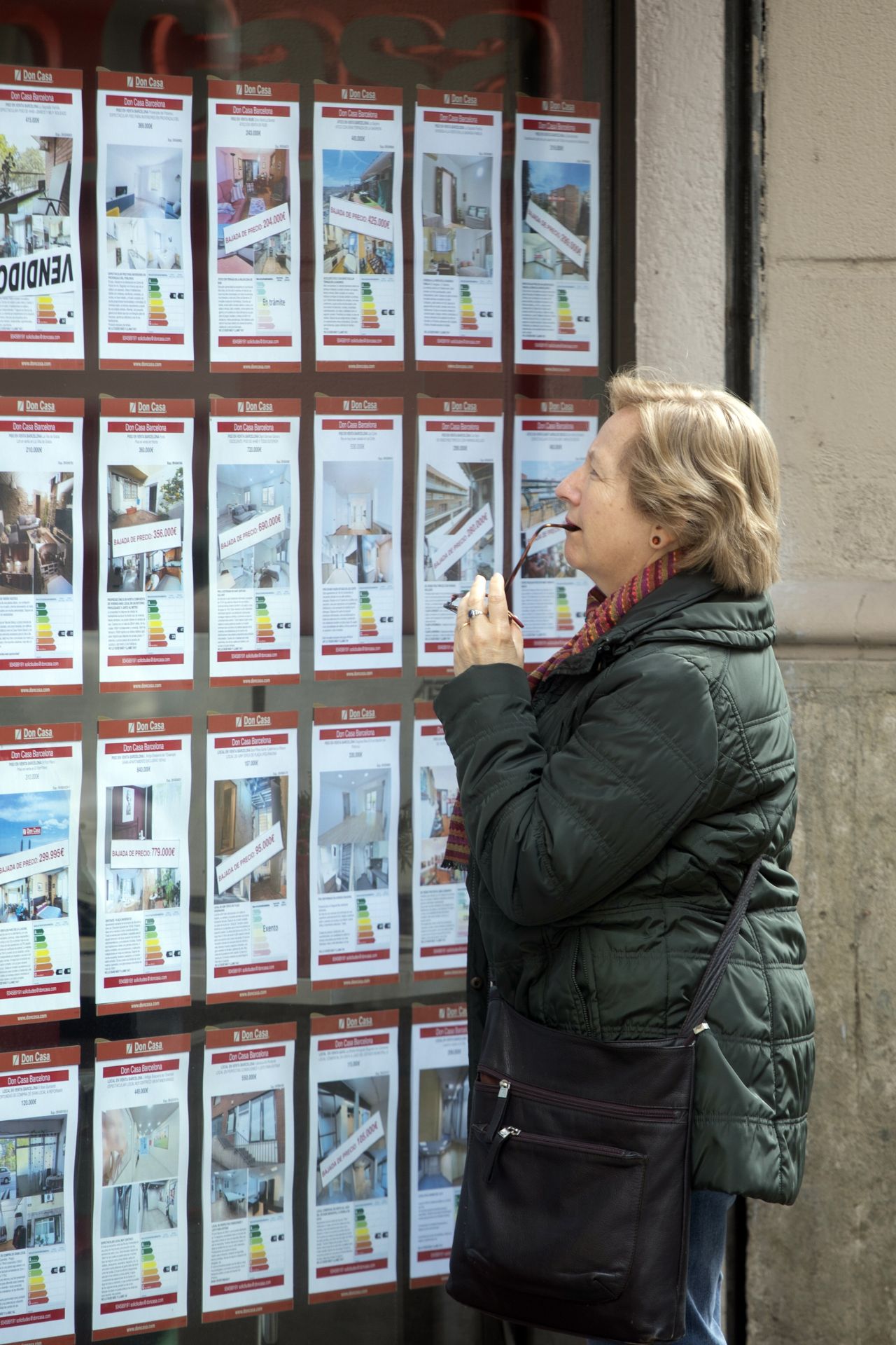 Una viandante examina los precios de una inmobiliaria.
