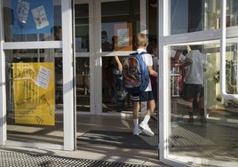 Un alumno entrando en su colegio el primer día de clase.