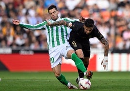 Lo Celso y Barrenechea disputan un balón durante el encuentro de la primera vuelta en Mestalla.