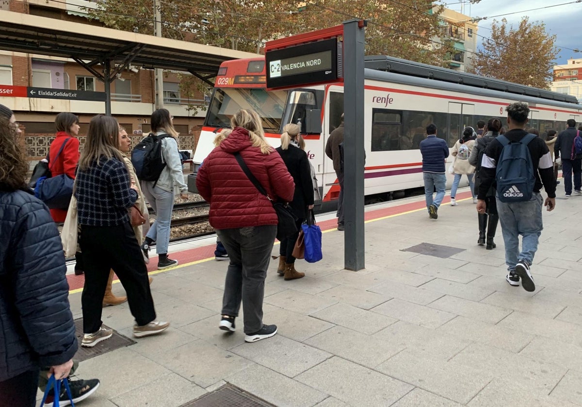 Unos viajeros se dirigen a un tren de cercanías.