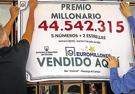 Dos afortunados ganadores del Euromillón cuelgan el cartel con el premio obtenido, en una imagen de archivo.