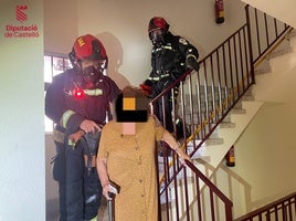 Los bomberos recatan a una mujer atrapada en el hueco de la escalera.