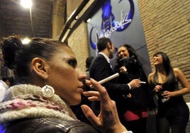 Una joven fuma un cigarrillo sin humo a las puertas de un pub, en una imagen de archivo.