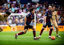 Carlos Álvarez controla el balón ante la mirada de los rivales.