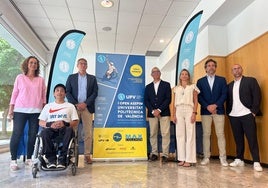 Representantes de los organizadores del evento posando con el cartel del torneo.