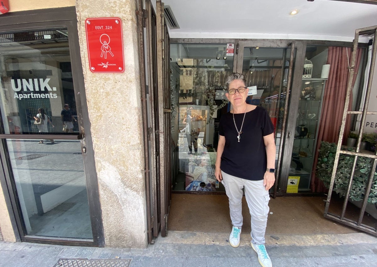 Imagen secundaria 1 - Balcón con un tapiz de la Virgen; Elisa Peris, de Peris Roca, con su negocio y justo al lado un apartamento turístico, y Ana y Paula, de la librería Praxis, en la calle Avenallas.