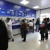 Clientes en una administración de loterías. Imagen de archivo.
