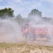 Bomberos forestales forman una cortina de agua de protección.