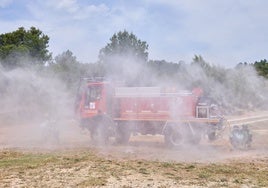 Bomberos forestales forman una cortina de agua de protección.