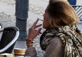 Una mujer fumando un cigarrillo.