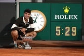 Alcaraz posa en el reloj que marca el tiempo que ha durado la final.