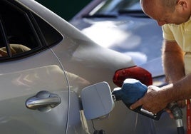 Una persona pone gasolina en su coche.