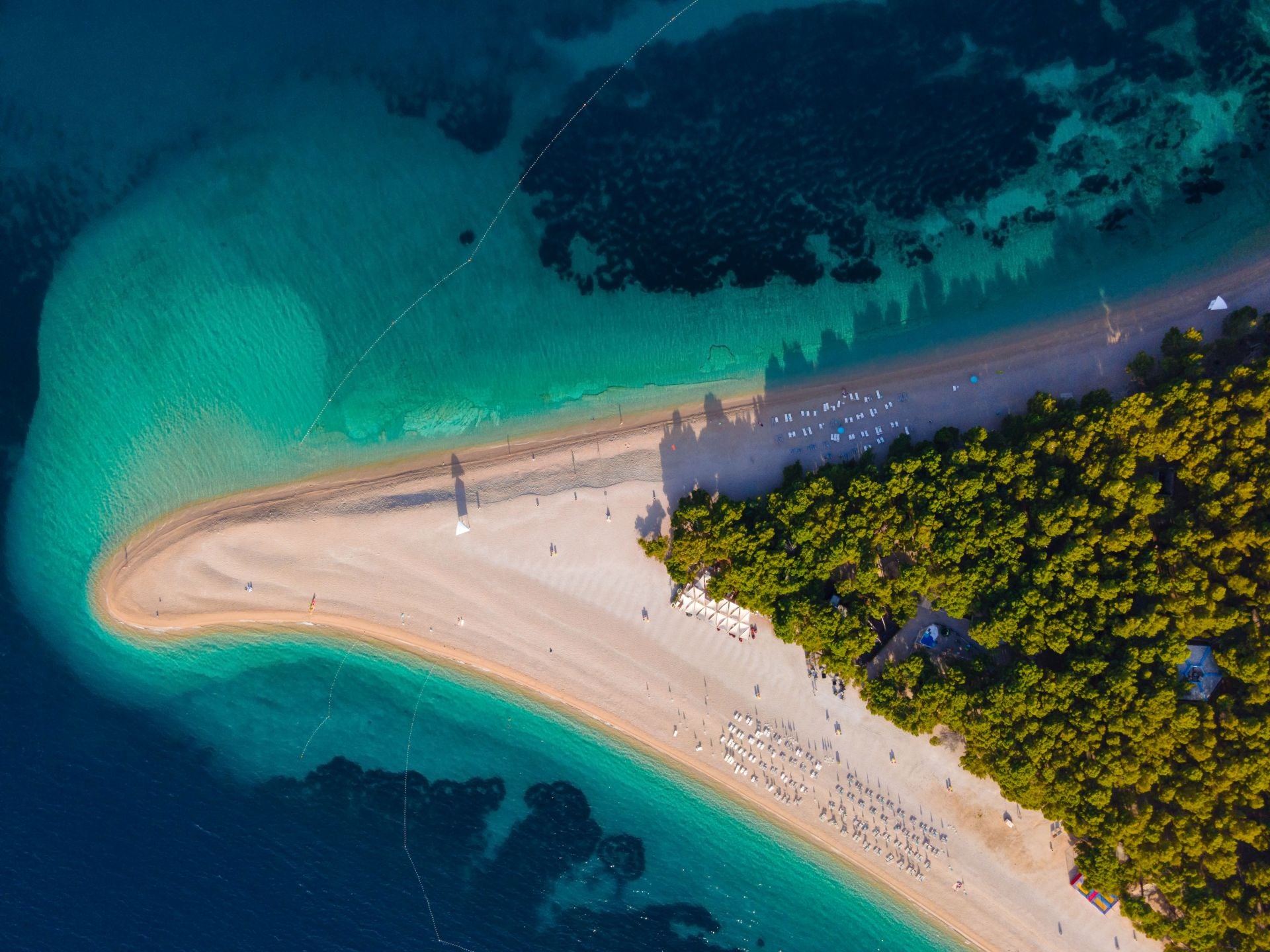 Zlatni Rat, Isla de Brač (Croacia). La describen como una «singular playa en forma de punta de lanza que se extiende como un cuerno dorado en el mar de casi mil metros de largo, acaricia el mar cristalino y turquesa y su extremo cambia de forma en un juego entre el viento, las olas y las corrientes marinas». «Se la considera como una de las mejores playas de Europa y del mundo y es un símbolo del turismo croata y de la belleza natural», añaden. También cuentan que «hay un bosque centenario de pino mediterráneo justo al borde del agua, donde encontrar fácilmente una sombra para escapar del sol durante las horas más calurosas del día». Además, los expertos desvelan que su belleza y popularidad hacen que sea una playa bastante concurrida, pero existen otras calas a lo largo de la costa de Brac mucho más tranquilas. Zlatni Rat es una reserva natural protegida y un destino codiciado tanto para los practicantes de kitesurf como para los surfistas.