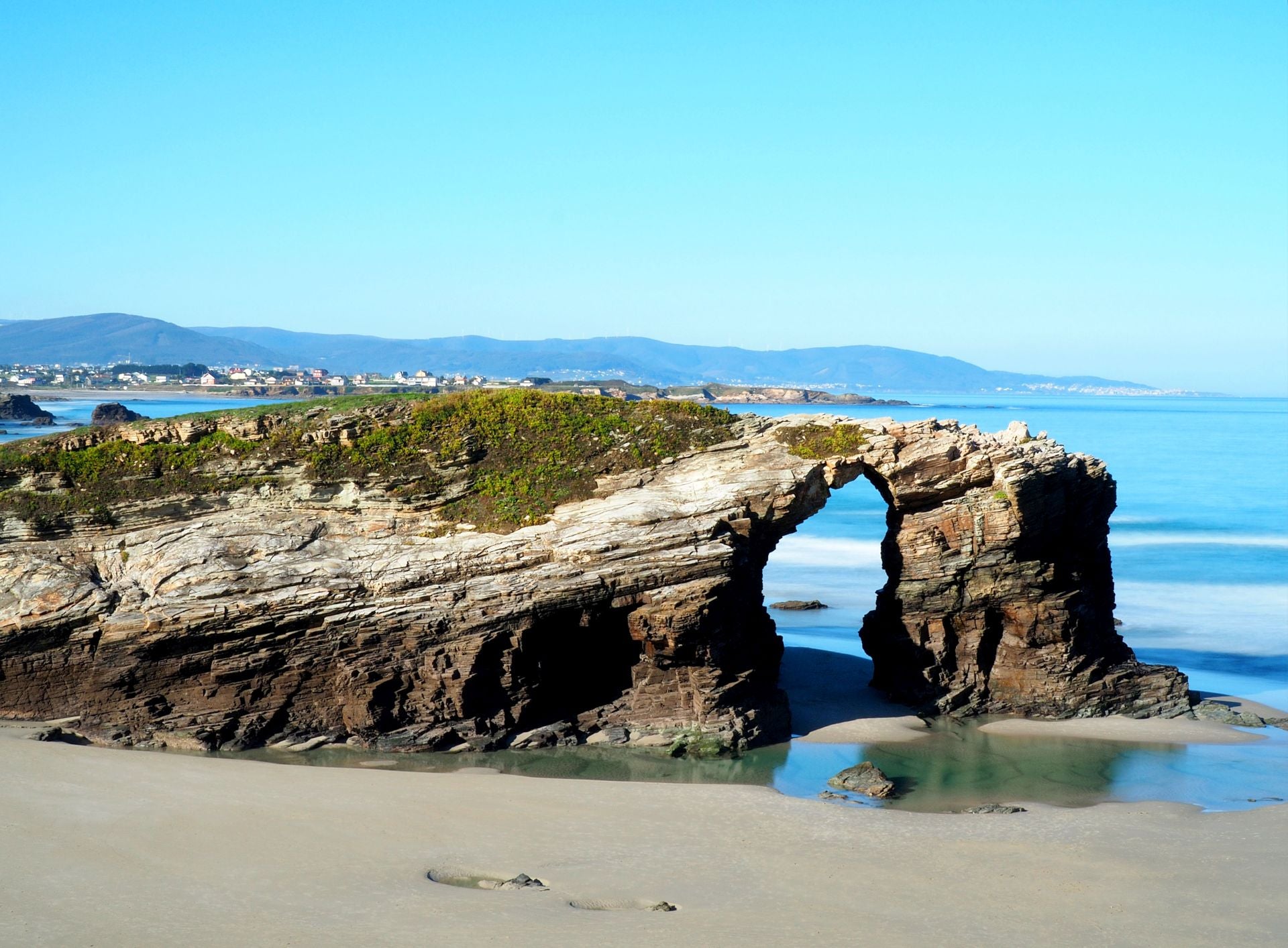 Playa de las Catedrales, Lugo, Galicia (España). Declarada Monumento Natural, los usuarios de Jetcost destacan de ella «sus formaciones rocosas creadas por el viento y el agua, que han llevado a crear curiosas formas». Además, añaden que «cuando baja la marea es posible descalzarse y caminar bajo cuevas y descubrir arcos dentro de otros arcos». También informan que «aunque la entrada es gratuita, para evitar aglomeraciones, es necesaria la reserva de entrada en los meses de julio, agosto y septiembre». Por último, destacan que se trata de «un lugar ideal para el disfrute de los niños, ya que al bajar la marea, junto a las rocas, se forman multitud de pequeñas pozas de agua cristalina que se templan cuando les da el sol».