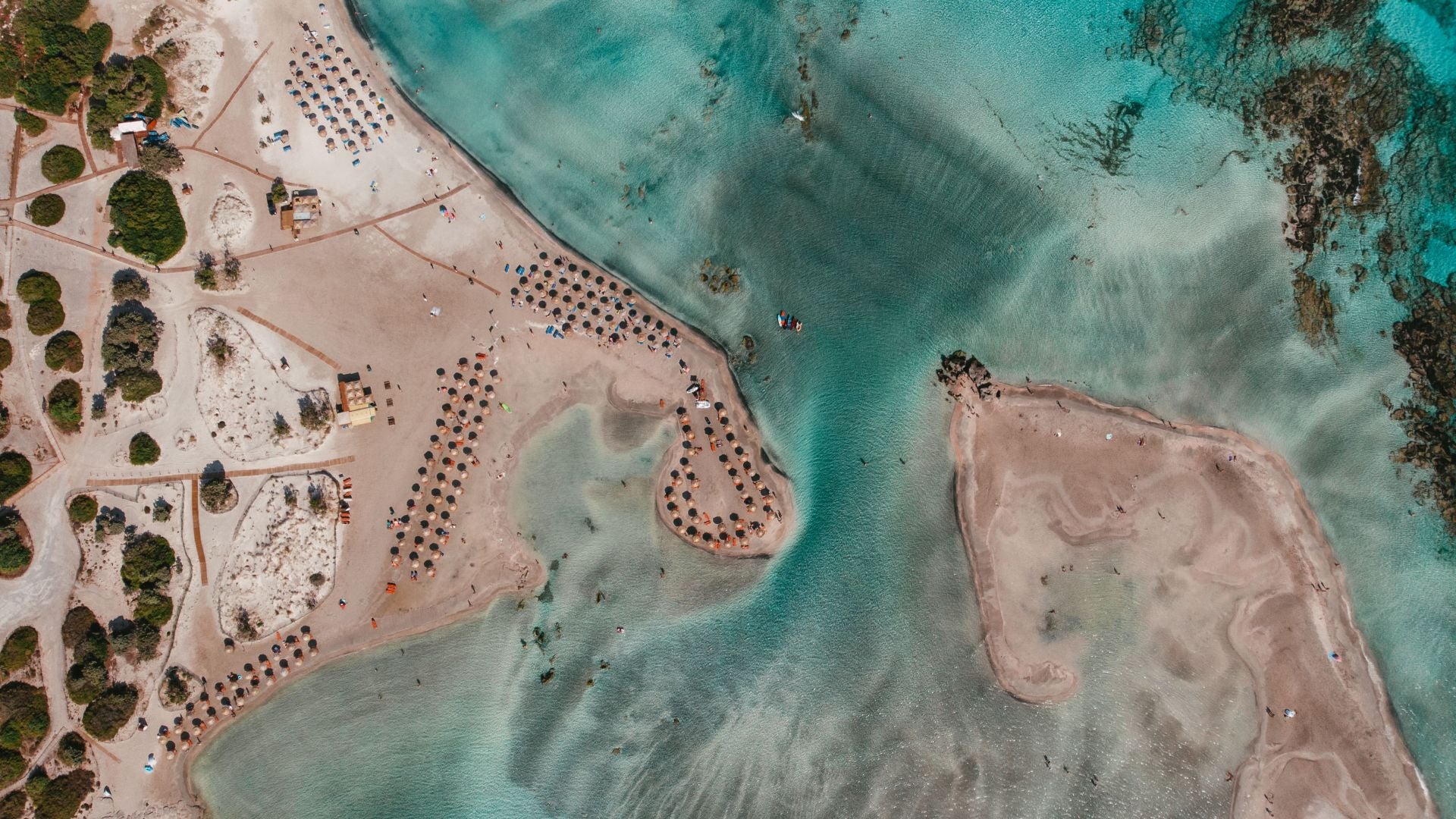 Playa Elafonisi, Creta (Grecia). Está situada en la costa suroeste de la isla de Creta y se considera a veces como el Caribe del Mediterráneo por su playa blanca con matices de rosa y el turquesa de sus cálidas aguas. Desde Jetcost indican que «justo en frente de la playa se encuentra la pequeña isla de Elafonissi que, según las mareas, a veces está conectada con el continente a través de una estrecha franja de arena, mientras que con la marea más alta es una isla real a la que se puede llegar caminando por las aguas del mar que llegan hasta las rodillas». De la isla explican que «solo hay playa libre y en particular la parte trasera es quizás la más bucólica y se caracteriza por pequeñas bahías donde reina la paz y la tranquilidad». Por último, los expertos de Jetcost recomiendan «no perderse uno de los momentos más bellos del lugar, cuando el sol se pone sobre las aguas del Mar de Libia dando un panorama de maravillosos colores».