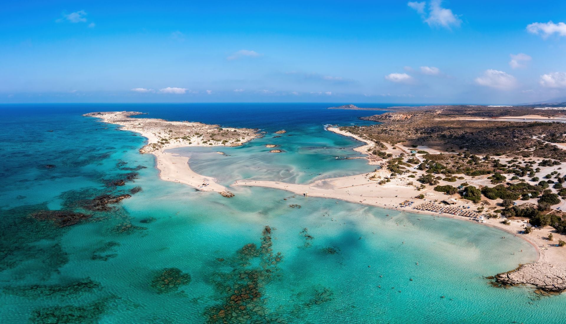 Playa Elafonisi, Creta (Grecia). Está situada en la costa suroeste de la isla de Creta y se considera a veces como el Caribe del Mediterráneo por su playa blanca con matices de rosa y el turquesa de sus cálidas aguas. Desde Jetcost indican que «justo en frente de la playa se encuentra la pequeña isla de Elafonissi que, según las mareas, a veces está conectada con el continente a través de una estrecha franja de arena, mientras que con la marea más alta es una isla real a la que se puede llegar caminando por las aguas del mar que llegan hasta las rodillas». De la isla explican que «solo hay playa libre y en particular la parte trasera es quizás la más bucólica y se caracteriza por pequeñas bahías donde reina la paz y la tranquilidad». Por último, los expertos de Jetcost recomiendan «no perderse uno de los momentos más bellos del lugar, cuando el sol se pone sobre las aguas del Mar de Libia dando un panorama de maravillosos colores».