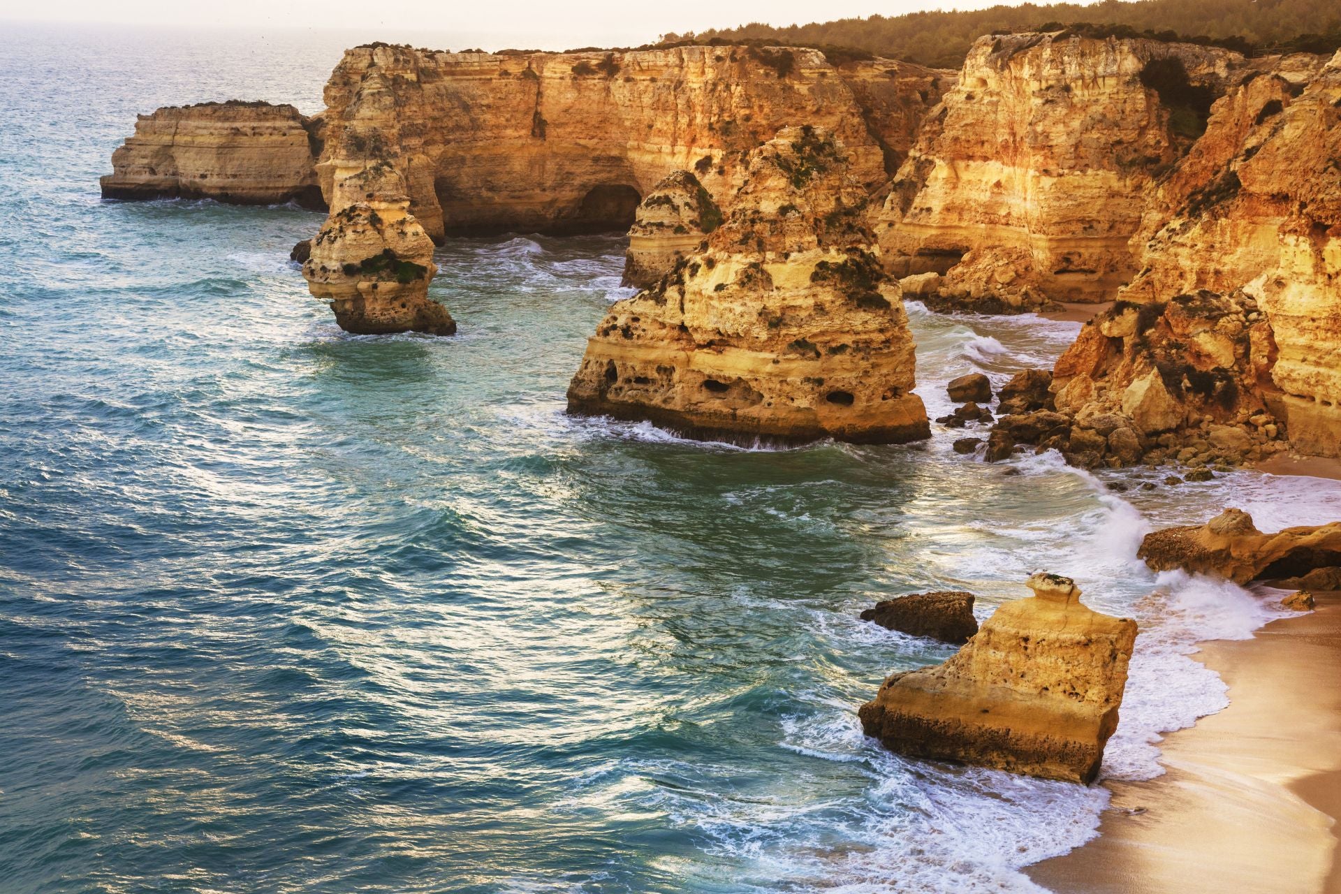 Praia da Marinha, Algarve (Portugal). A unos 60 kilómetros de Faro, hacia el oeste, se encuentra Praia da Marinha, «considerada la más bella del sur de Portugal y una de las 10 playas más bellas de Europa». Según explican desde Jetcost, «para disfrutarla, vale la pena madrugar y visitarla muy pronto por la mañana». Entre su belleza destaca «las formas caprichosas de los monolitos rocosos y la gama de colores que la inundan la convierten en una joya». Los expertos invitan a «dar un paseo, comer buen marisco, beber vinho blanco o verde y luego darse un baño», algo que describen como «un placer». «Existe la posibilidad de coger una barquita y descubrir grutas ocultas en ese tramo de la costa», terminan.