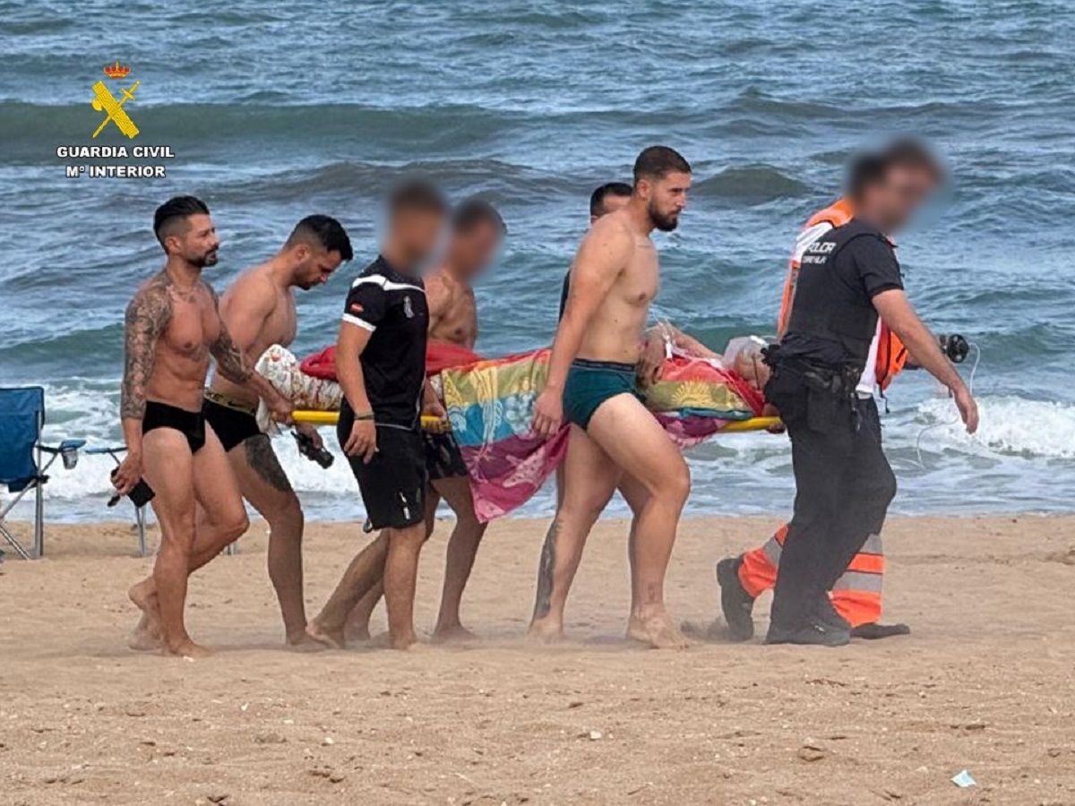Momento en el que el hombre es trasladado por la playa tras ser sacado del mar.