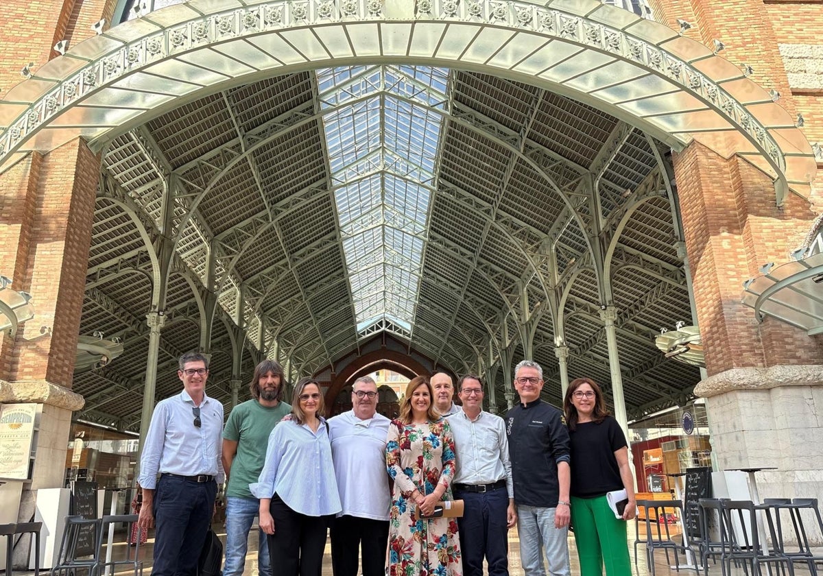 La alcaldesa de Valencia, María José Catalá, el concejal de Urbanismo Juan Giner y el gerente de Aumsa, Ignacio Calabuig, junto con los vendedores del Mercado de Colón.