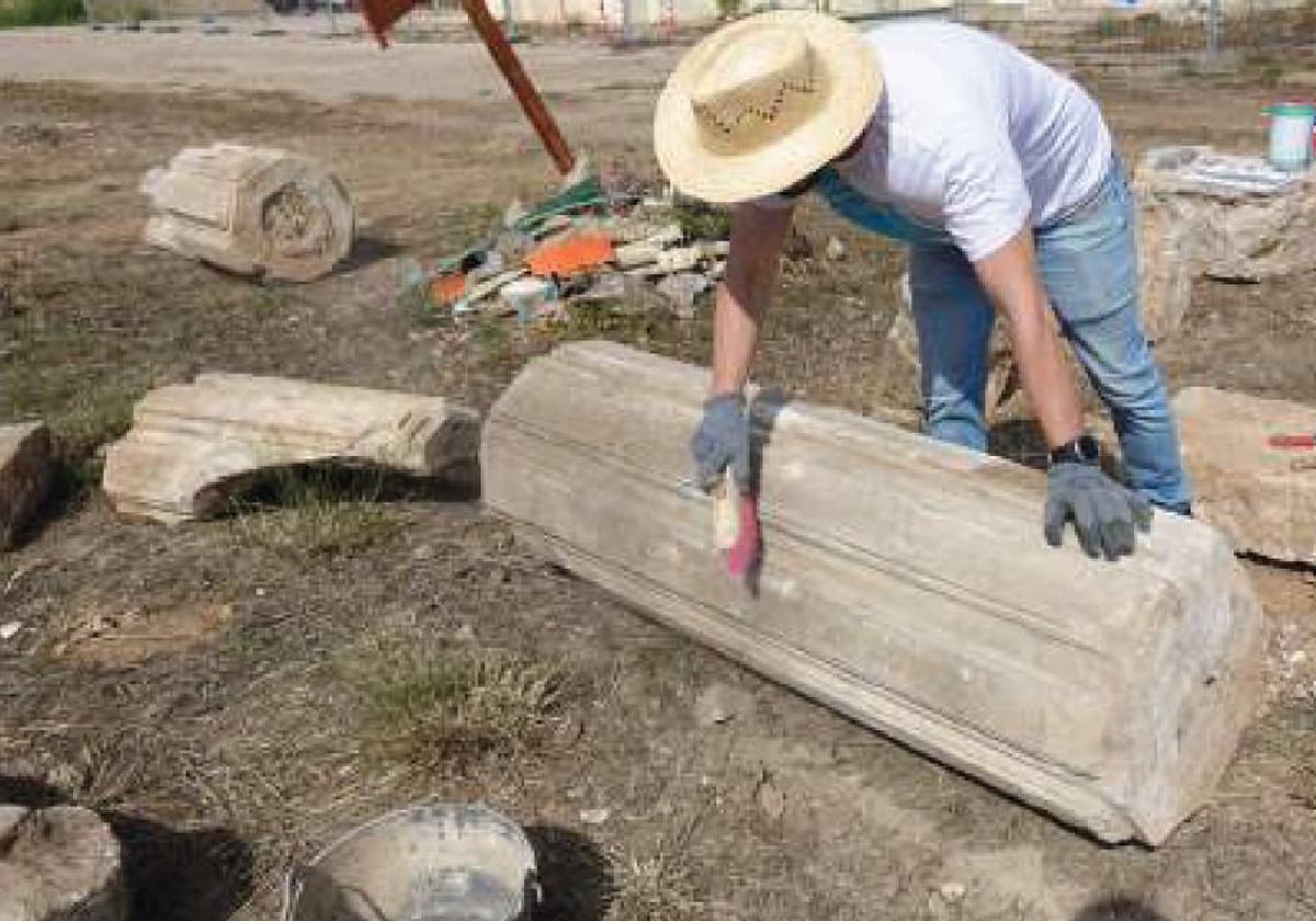 Un técnico limpia una de las piezas de la columnata.