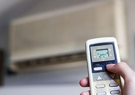 Una persona enciende un aparato de aire acondicionado