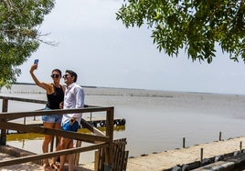 Una pareja se hace fotos al pie de la laguna