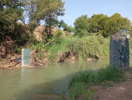 El río a su paso por Pedralba, con los restos del puente de hierro.