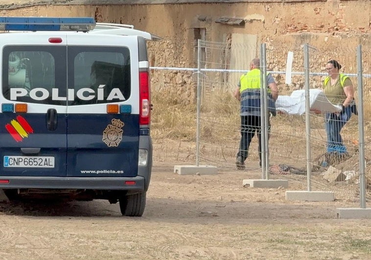 Dos empleados del retén fúnebre trasladan el cuerpo de la víctima.