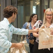 Una pasajera recibe la bolsa de cortesía de Visit Valencia.