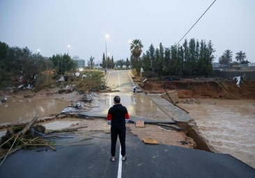 Un hombre, ante una carretera destrozada por la dana en Torrent.