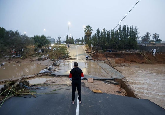 Un hombre, ante una carretera destrozada por la dana en Torrent.