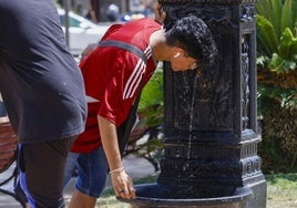 Un joven bebe agua de una de las fuentes de Valencia tratando de refrescarse.