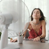 Una mujer intenta refrescarse con un ventilador.