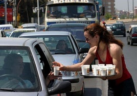 Una mujer repartiendo horchata entre los coches en Alboraya en una imagen de archivo.