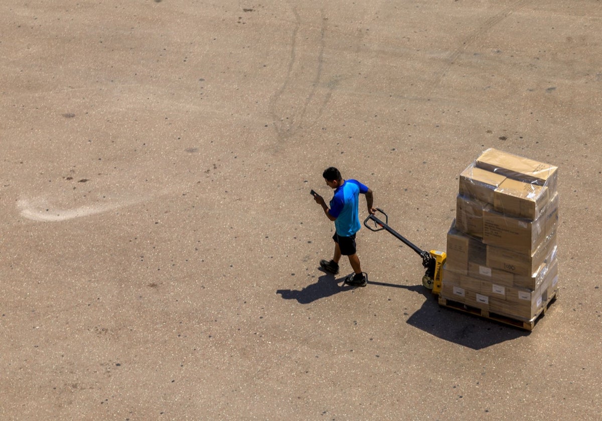 Un hombre transporta varias cajas en Valencia.