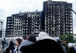 Un grupo de personas, poco después del incendio en Campanar, ante el edificio calcinado.