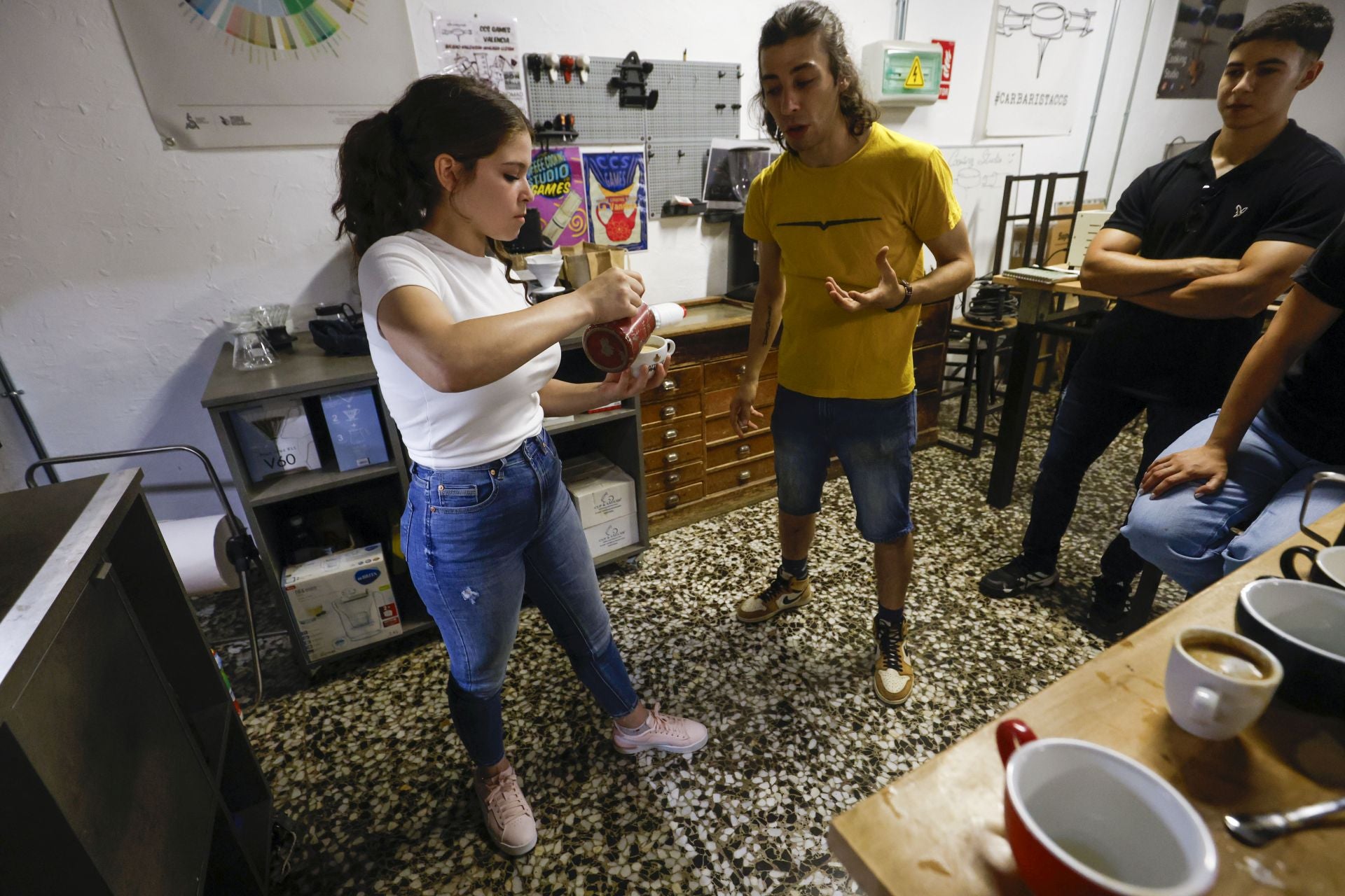 Una alumna, practica lo aprendido durante un curso de 'latte art'