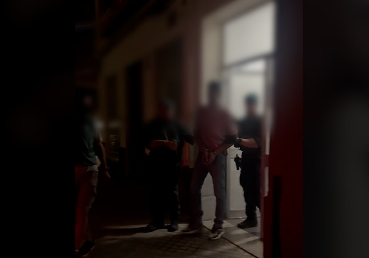 Dos guardias civiles trasladan al detenido.