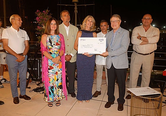 Los miembros del Real Club Náutico de Valencia dando el cheque solidario.