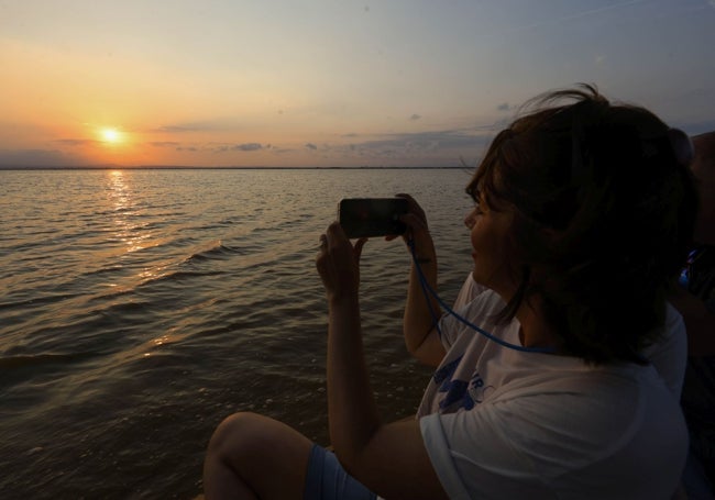 Una mujer toma una fotografía desde la barca.