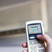 Una persona enciende un aparato de aire acondicionado