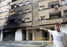 Un vecino muestra el edificio manchado por el humo.