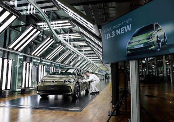 Un empleado de Volkswagen, junto al nuevo modelo eléctrico en la fábrica de Dresden.