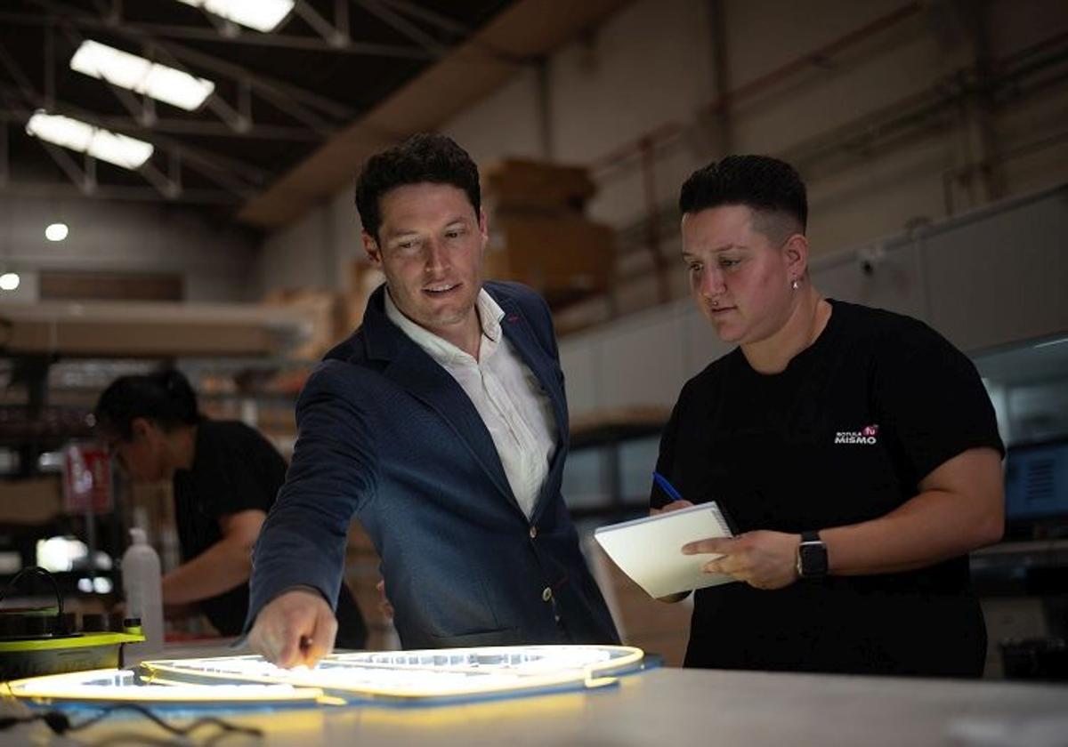 Víctor Ruiz, CEO de Rotula Tú Mismo, revisa junto al equipo uno de los diseños de neón personalizados en las instalaciones en Valencia