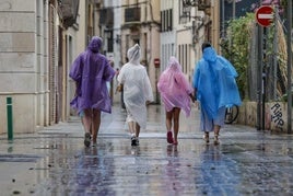 Varias personas se protegen de la lluvia en Valencia