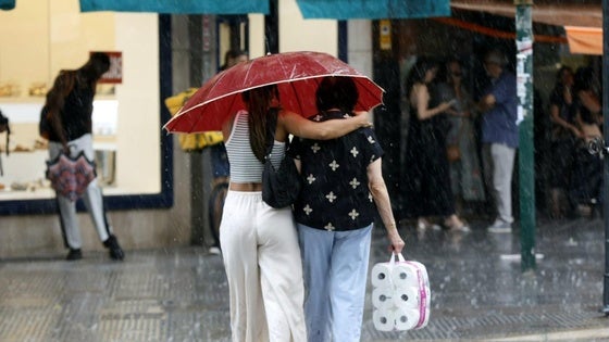 Dos mujeres pasean por la calle en Valencia, hoy.