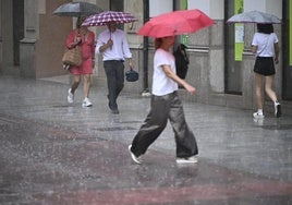Varias personas se protegen de la lluvia en Castellón.