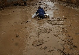 Una mujer cae sobre el barro de la dana en Paiporta.