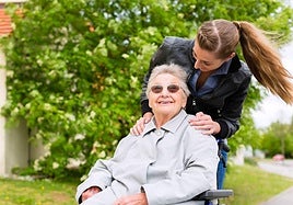 Una mujer junto a una persona mayor.