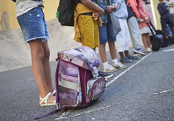 Alumnos esperan para entrar en clase.